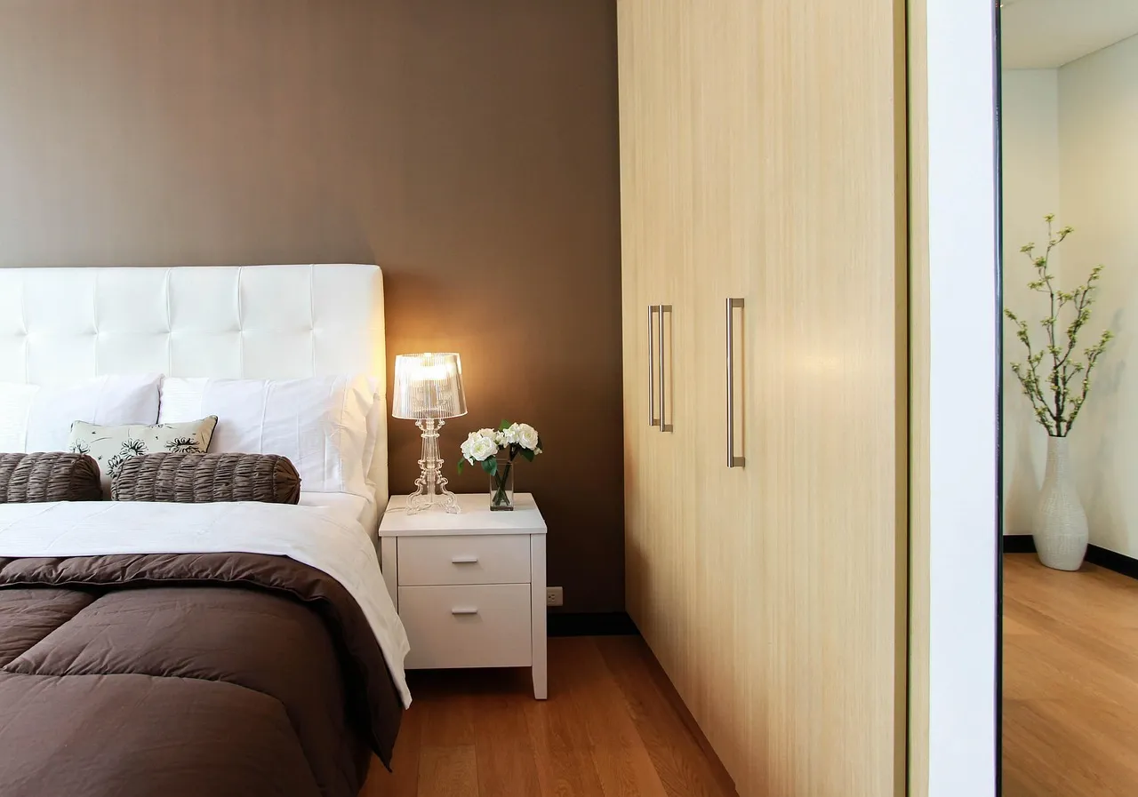 Un dormitorio tranquilo con la luz cálida de una lámpara de noche — el entorno donde empieza a mejorar el sueño